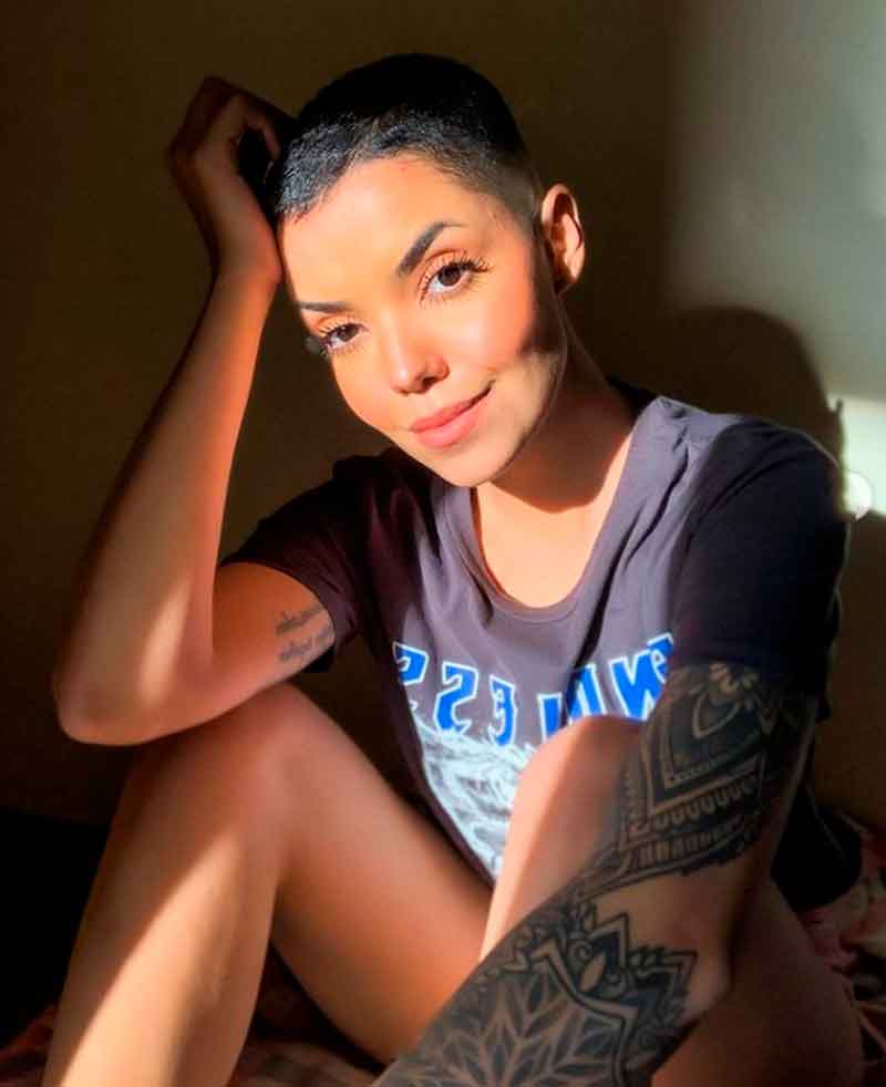 Mulher jovem tatuada com cabelo raspado feminino