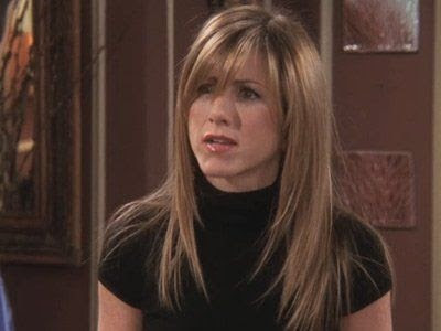 Imagem da atriz Jennifer Aniston no seriado Friends, na década de 1990, com um corte curto e franja toda ondulada.