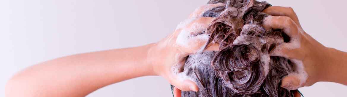 Lavando cabelo com shampoo para manter os cuidados com a raiz do cabelo skincare capilar