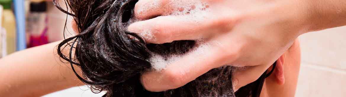 Mulher lavando o cabelo com espumas, tutorial de como lavar corretamente cada tipo de cabelo e curvatura