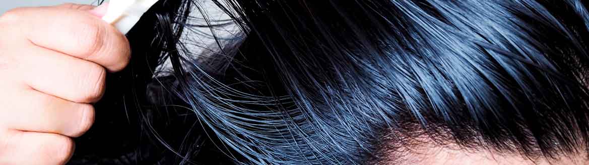 Close zoom em cabelo preto liso oleoso sendo penteado com escova branca em fundo neutro