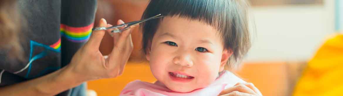 Pais cortando o cabelo de criança pequena com tesoura na franja como fazer