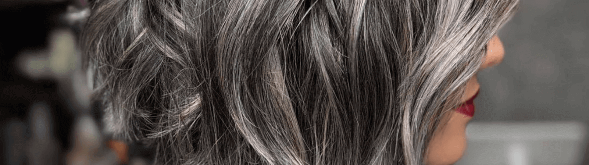 Grey Blending: modelo feminina posa de perfil para mostrar seu cabelo que mescla tons de castanho claro e cinza.